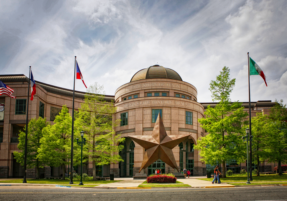 Front of the Bullock Texas State History Museum, one of the best things to do in Austin. Large concrete building with small domed ceiling and large star sculpture in front