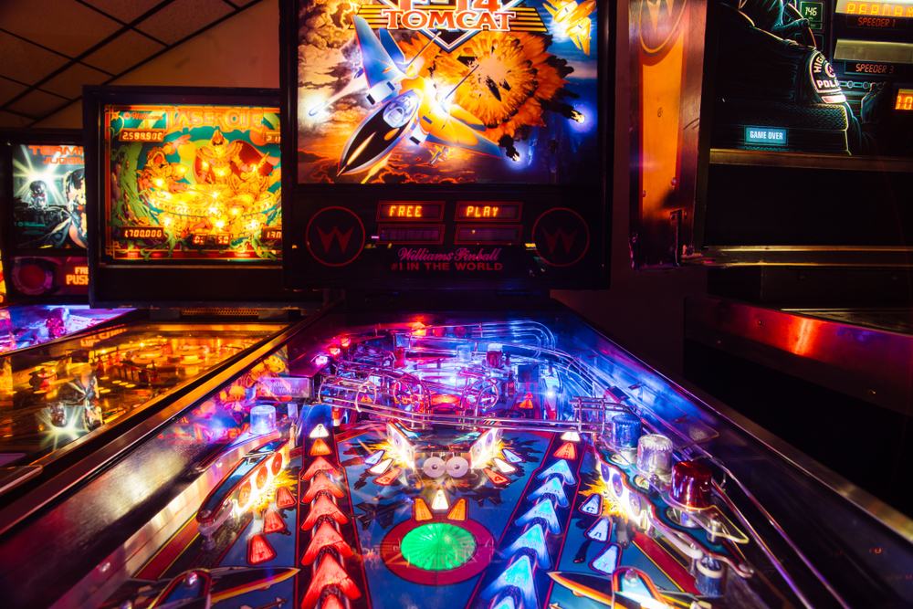 Pinball machine lit up against dark background