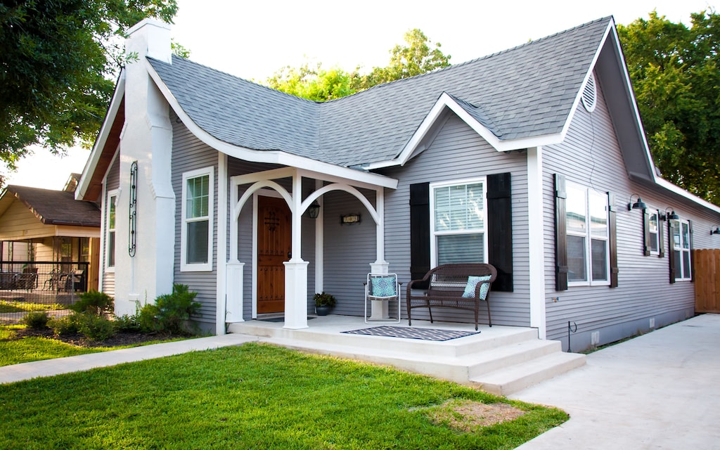 Charming grey house with a large front porch and lots of curb appeal. 