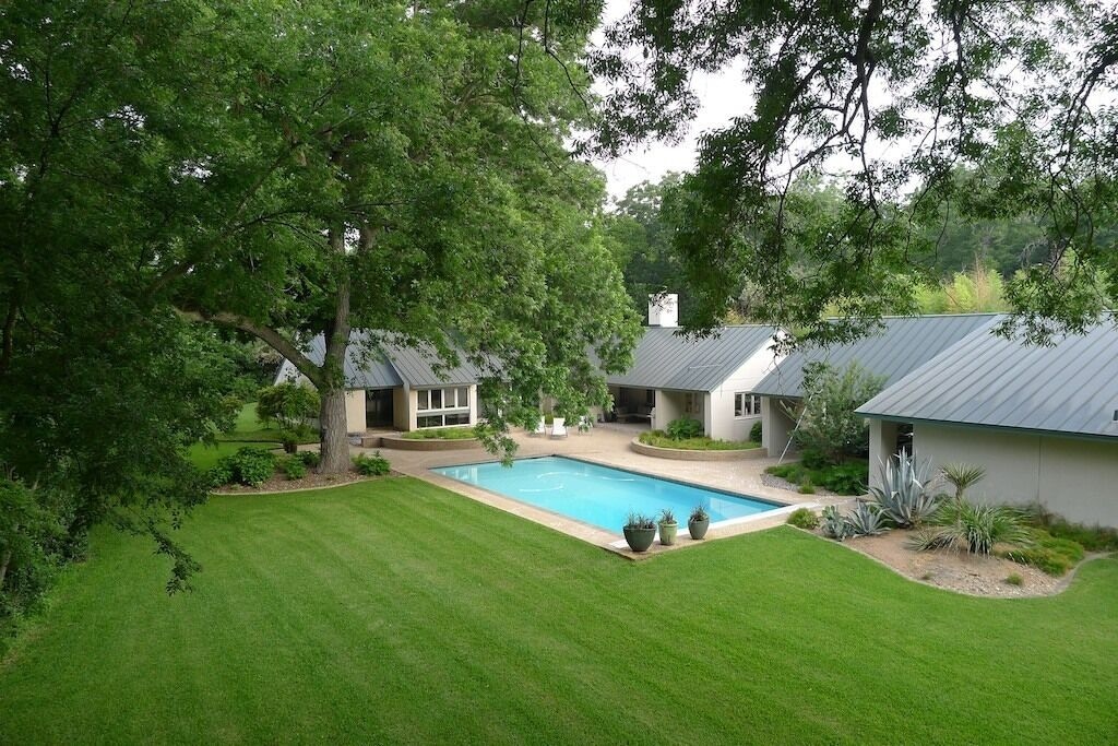 The sweeping lawn and 300 year old pecan tree framing the full sized pool on this property. This is one of the best airbnbs in San Antonio. 