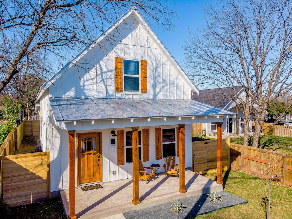 The white exterior with wooden shutters of this Urban Farmhouse. It has a very cute tin roof front porch. This is one of the best Airbnbs in San Antonio.