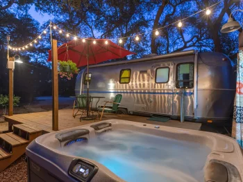 airstream camper with lights and hot tub for glamping in texas