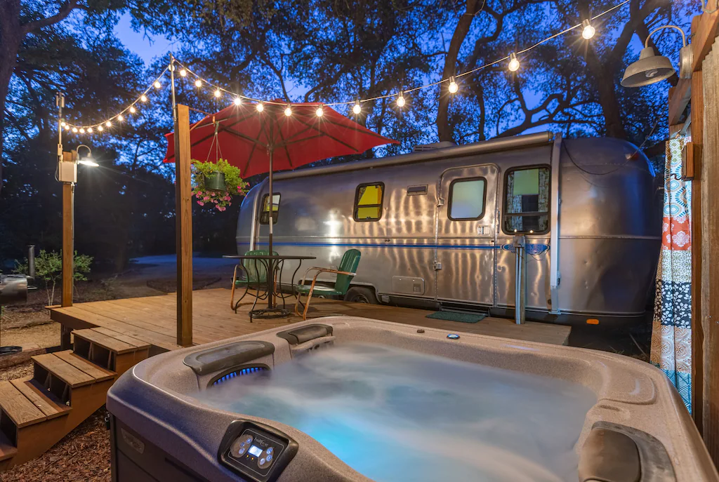 airstream camper with lights and hot tub for glamping in texas