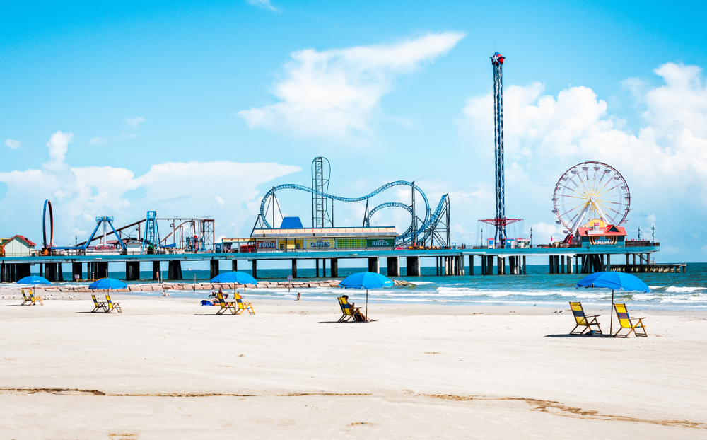 The Galveston Island Pleasure Pier during a bright and sunny day with blue skies.