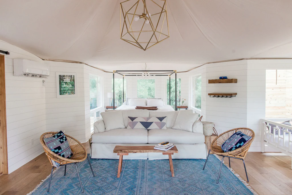 The inside of a glamping tent with a couch, wide windows, and comfortable seats one of the best places to visit in texas