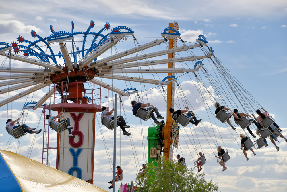 People swing on a rotating swing at Playland Amusement Park one of the best places to visit in texas