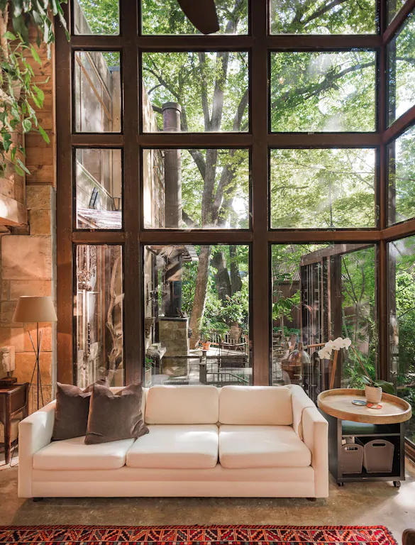 The wall to ceiling windows of this treehouse explore the nature of texas vacation spots