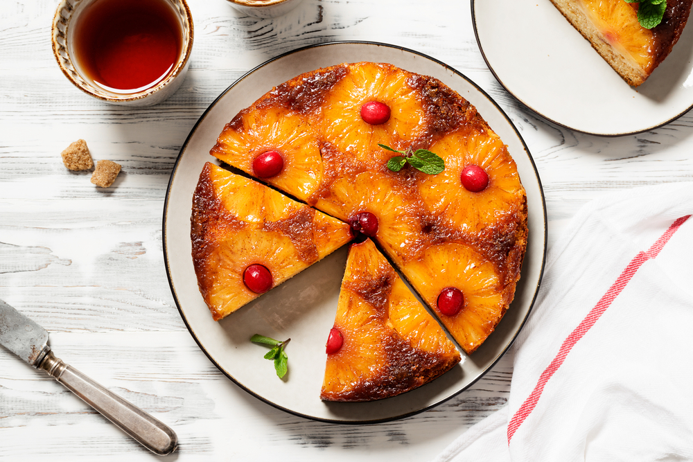 overhead view of pineapple upside down cake with some slices cut