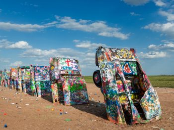 colorful cadillac buried in soil horizontally route 66 in texas