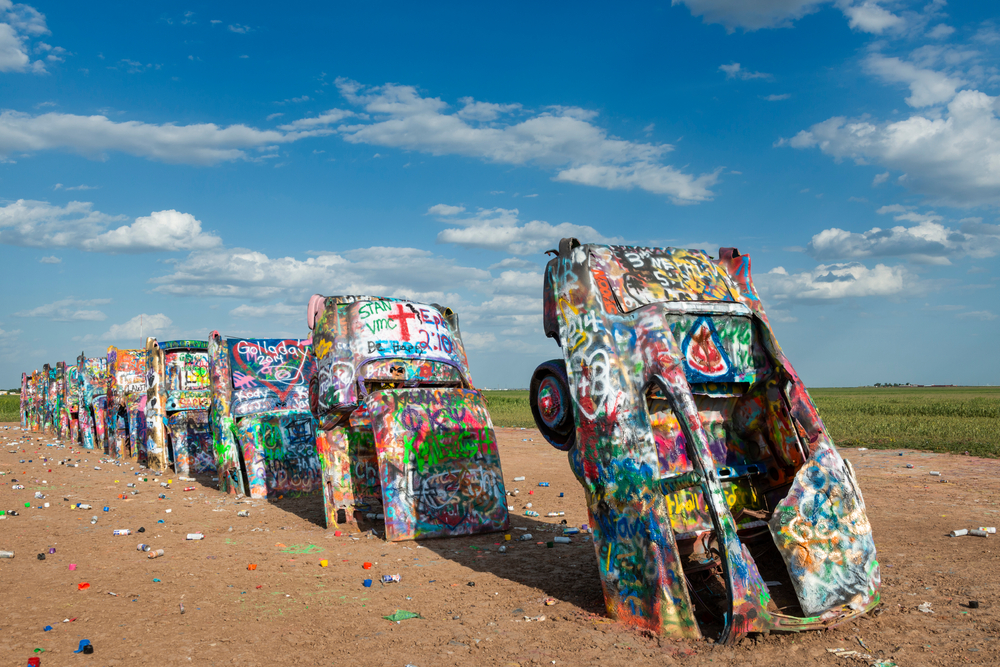 colorful cadillac buried in soil horizontally route 66 in texas