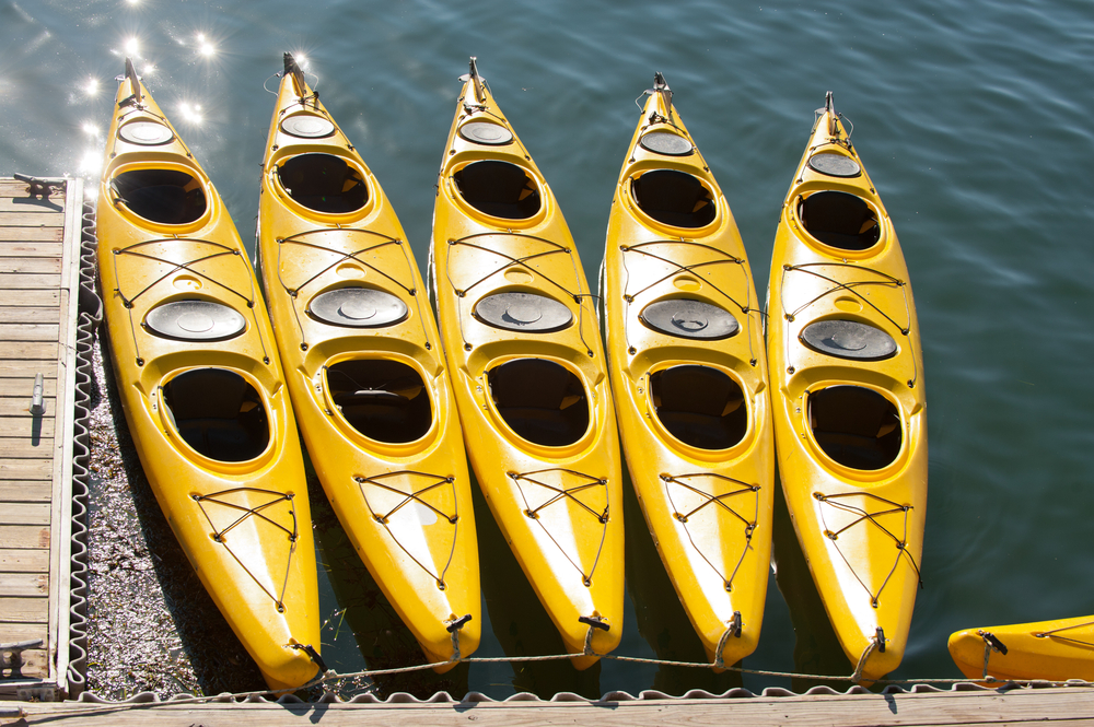 5 yellow kayak boats parked at harbor