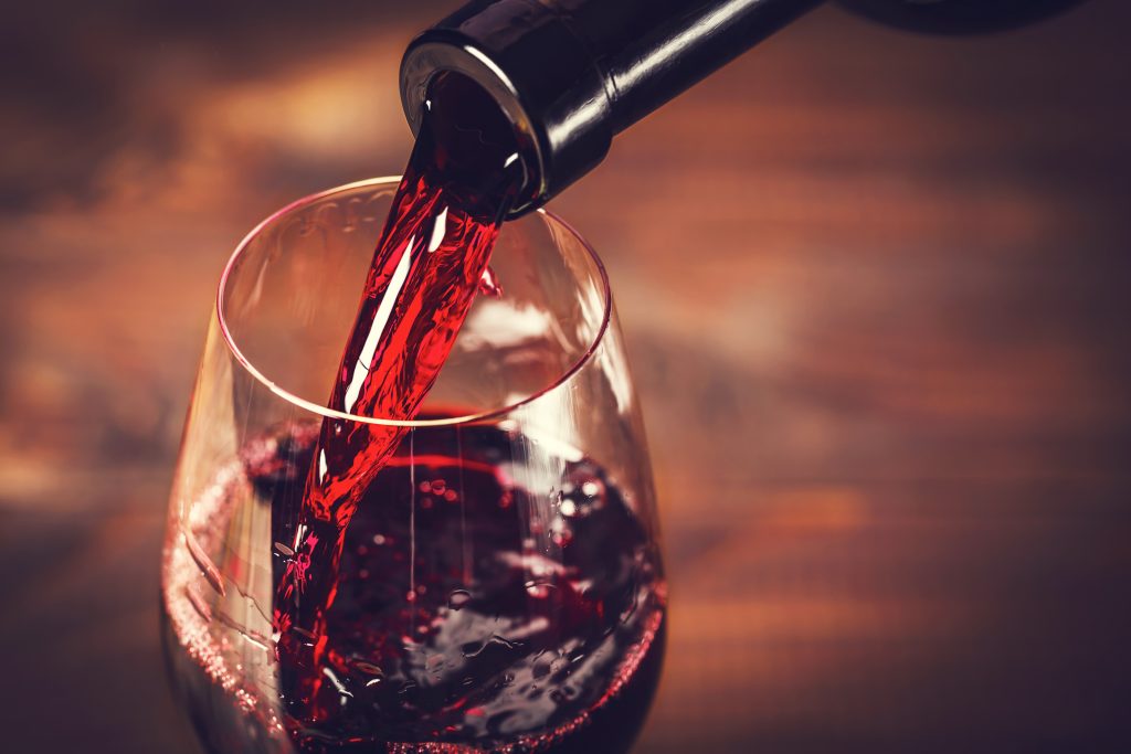 Close up of red wine being pored into a wine glass 