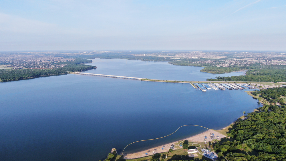 This overview photo of Joe Pool Lake shows that this is one of the largest lakes in Dallas, with a bridge running through it, and boat ramps, and shorelines and more. 