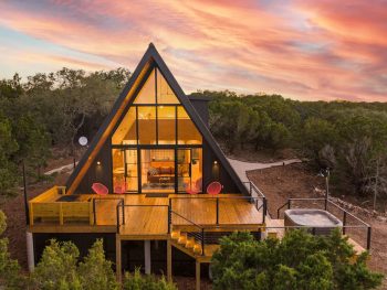 exterior of an aframe cabin in texas at sunset