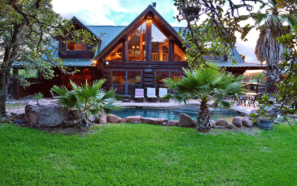 Photo of the pool and exterior of the Main Cabin and Bunk House, one of the best luxury cabins in Texas!