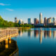 Photo of walking path along Town Lake with Austin in the background. Town Lake is one of the best lakes in Austin.