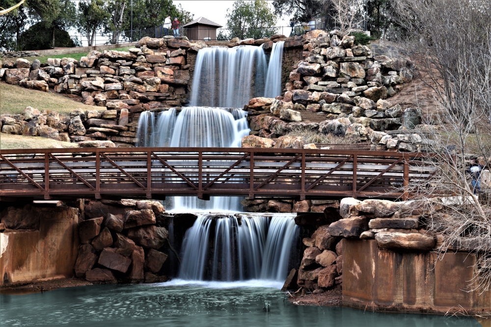 cascading waterfall with a bridge in front of it things to do in wichita falls