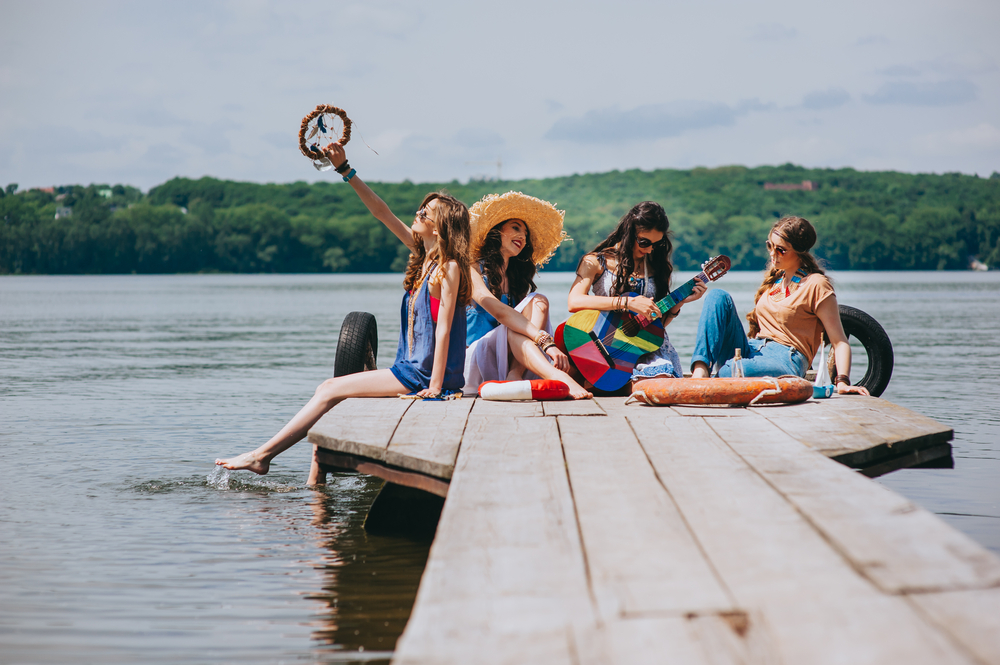 Photo of women sitting on a dock of one of the many lakes in Dallas, a great idea for a Dallas bachelorette party on a budget!