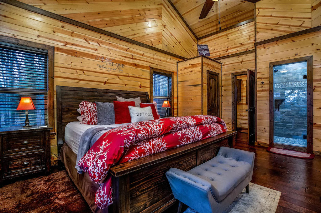 wooden cabin with antique furnishings and red quilt on the bed