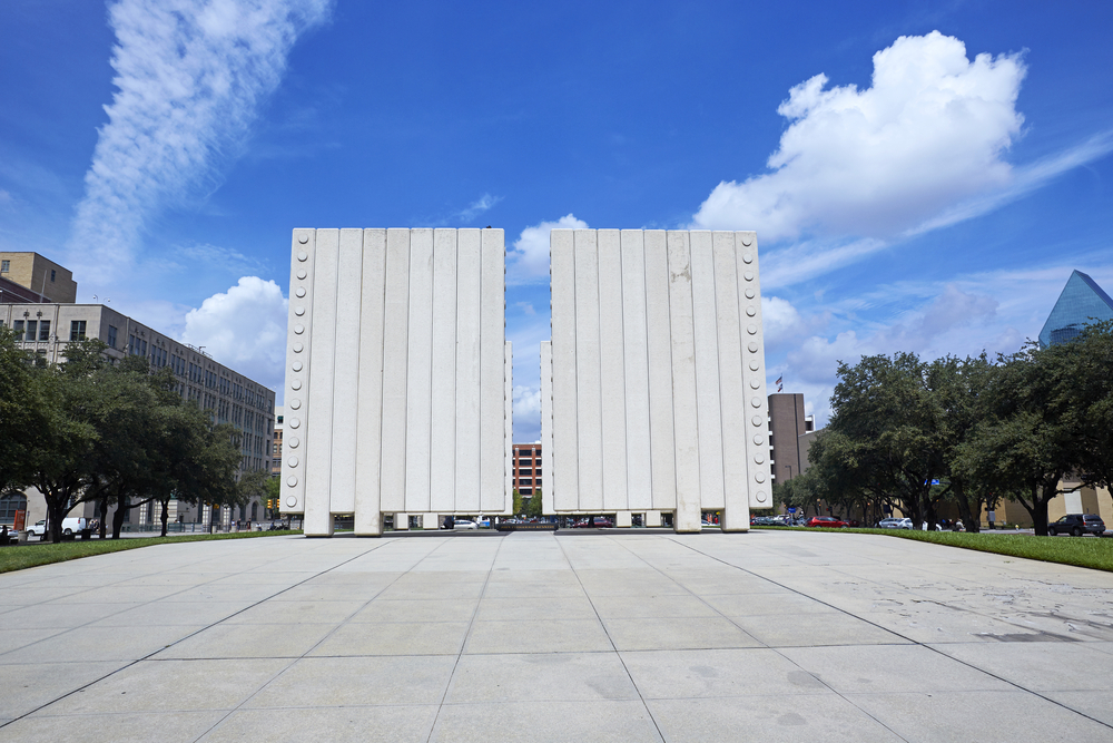 Look straight at the two white towers that make up the JFK Memorial Plaza on a sunny day during a weekend in Dallas.