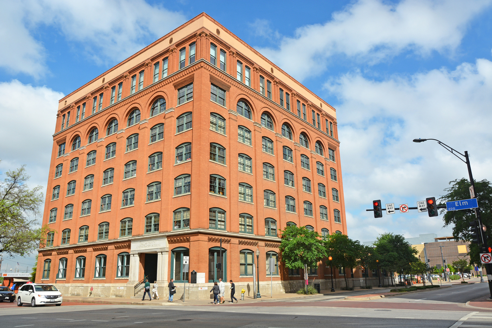 The exterior of the Texas School Book Depository Building on a sunny day. 