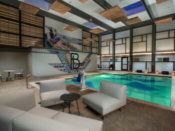 indoor swimming pool with poolside sofas and seating area