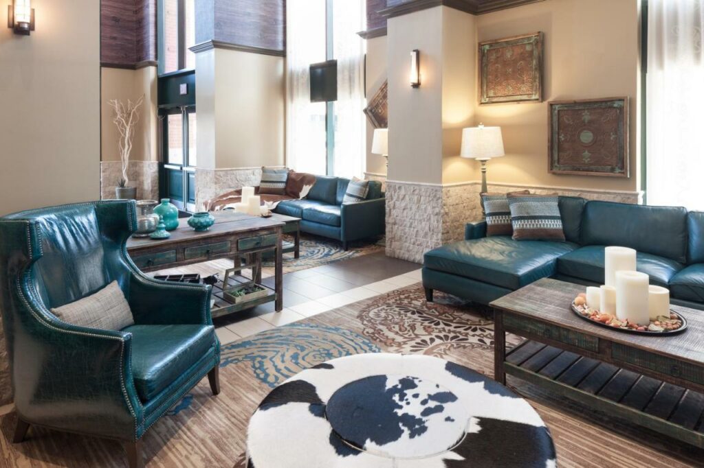 The teal couches, cow-hide coffee tables, and overall modern decor makes Spring Hill suites where to stay in Dallas. 