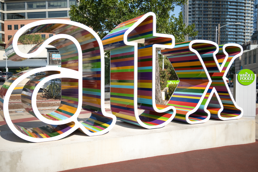 A giant sign that reads ATX in all rainbow colors welcomes people and encourages them to look into where to stay in Austin. 