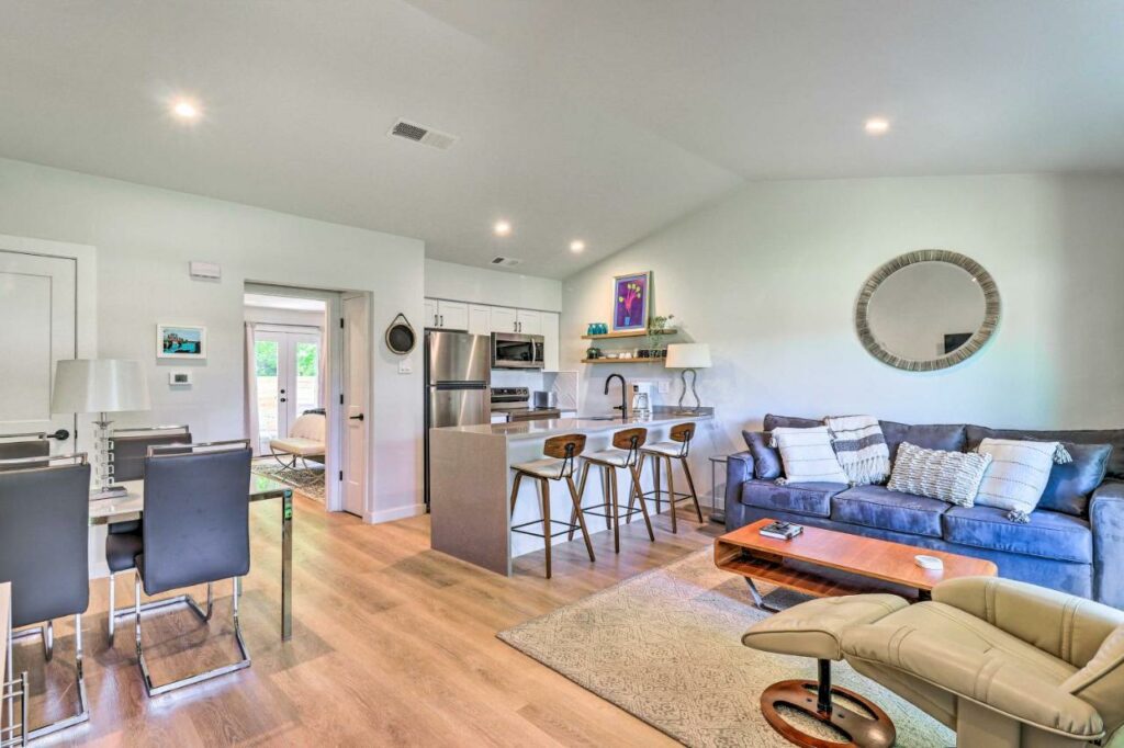 In a remodeled townhome near Zilker, the living room and kitchenette welcome guests with a comfortable ambiance, making it where to stay in Austin. 