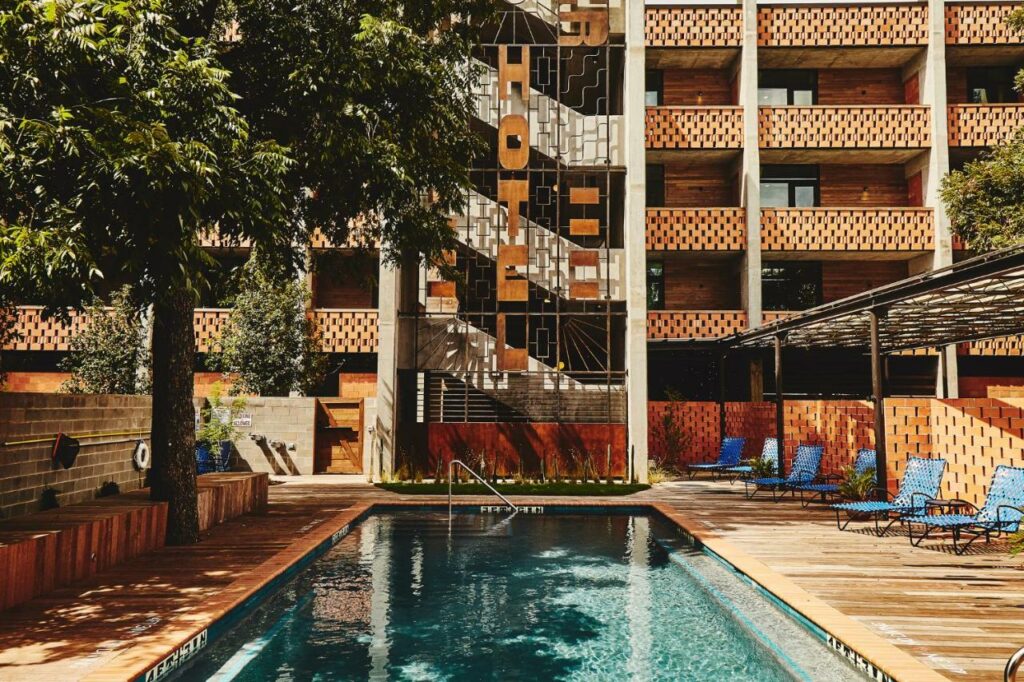 The pool deck of the Carpenter Hotel is where to stay in Austin: it gives off great 70's vibes with its orange coloring and unique structure. 