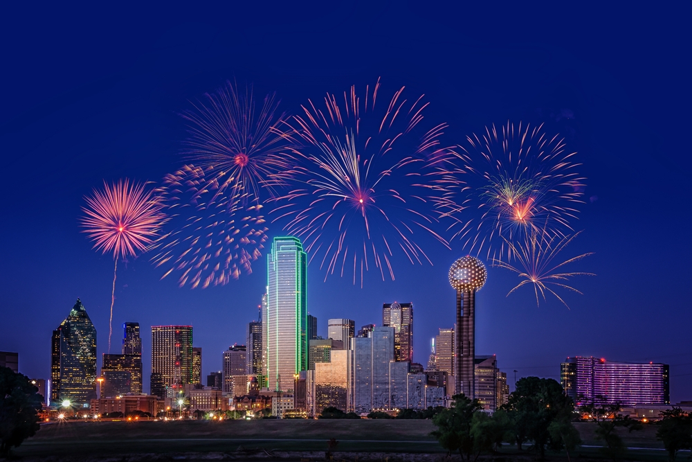 Photo of fireworks going off above the Dallas skyline at night. 