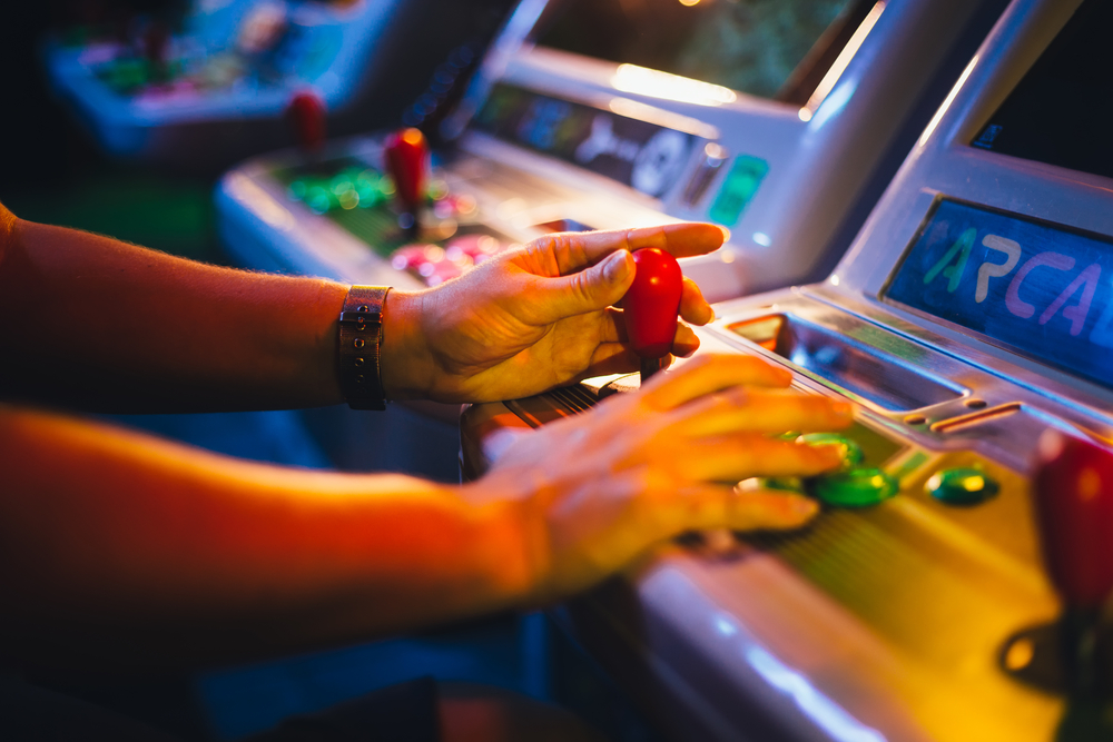 When looking for the best things to do in Houston at night, consider gaming! These hands are playing a classic arcade game, joystick and all! 