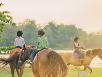 Photo of three kids horseback riding at Cypress Trails Ranch, one of the best things to do in Houston with kids.