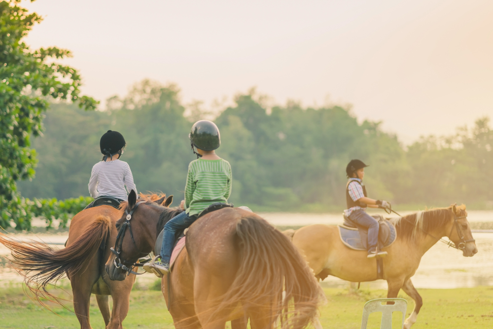 Photo of three kids riding horseback at Cypress Trails Ranch.